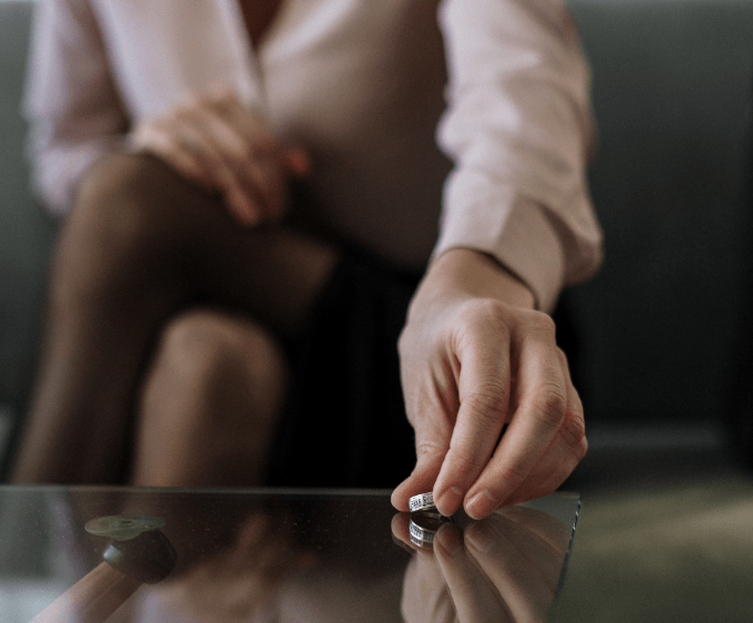 A person putting down a wedding ring.
